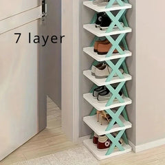 A seven-layer white shoe rack with teal X-shaped supports standing against a wall.