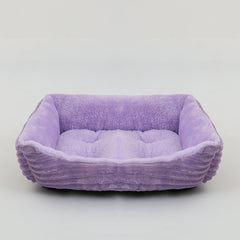 A rectangular purple plush pet bed with ribbed sides and a soft cushioned interior.