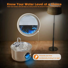 A stainless steel pet water fountain with an illuminated water level window on a wooden floor.