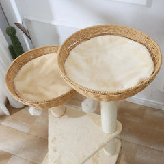 A two-tier cat tree featuring two round handwoven rattan baskets with soft cream-colored cushions.