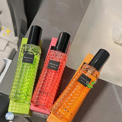 Three bottles of Peach Jo fragrance spray with textured glass in green, pink, and orange.
