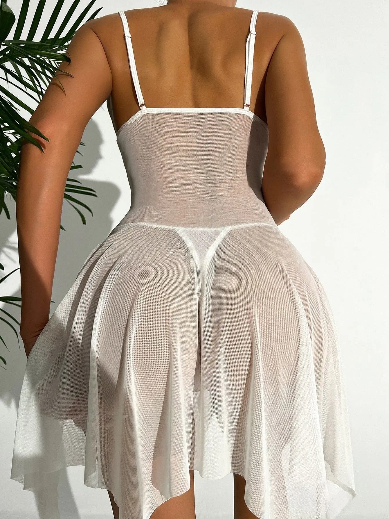 A person wearing the Sex Clothes Open Crotch Bra Lace Sleepwear Erotic Hot Sexy Costumes Wedding Erotic Bodysuit poses with their back to the camera in sunlight, with a green plant visible on the left side of the image.