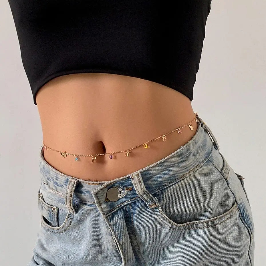 A woman wears a black crop top, light blue jeans with an open waistband, and a Sexy Vintage Aesthetic Belly Chain Thin Beads Link Body Chain Waist Chain Belt, adding Y2K streetwear flair with colorful bead charms to her summer fashion look.