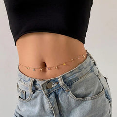 A woman wears a black crop top, light blue jeans with an open waistband, and a Sexy Vintage Aesthetic Belly Chain Thin Beads Link Body Chain Waist Chain Belt, adding Y2K streetwear flair with colorful bead charms to her summer fashion look.