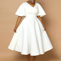 A woman wears a white mid-calf A-line dress with a V-neck and butterfly sleeves.