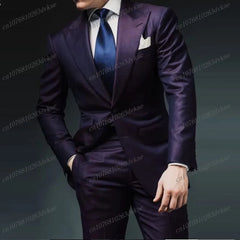 A man wears a formal two-piece brown suit with a white shirt and a blue tie.