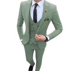 A man wears a slim-fit sage green three-piece suit with a patterned tie and gold lapel chain.