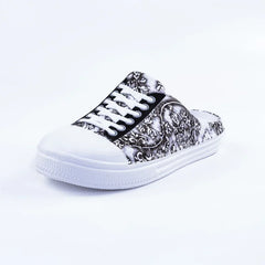 A black and white floral print slip-on sneaker with white laces and a round toe.