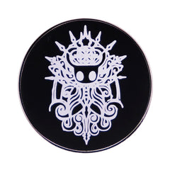 A circular black enamel pin featuring a white, intricate, stylized character design.