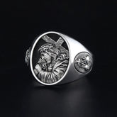 A silver ring featuring an embossed image of Jesus carrying a cross and a sacred heart emblem.
