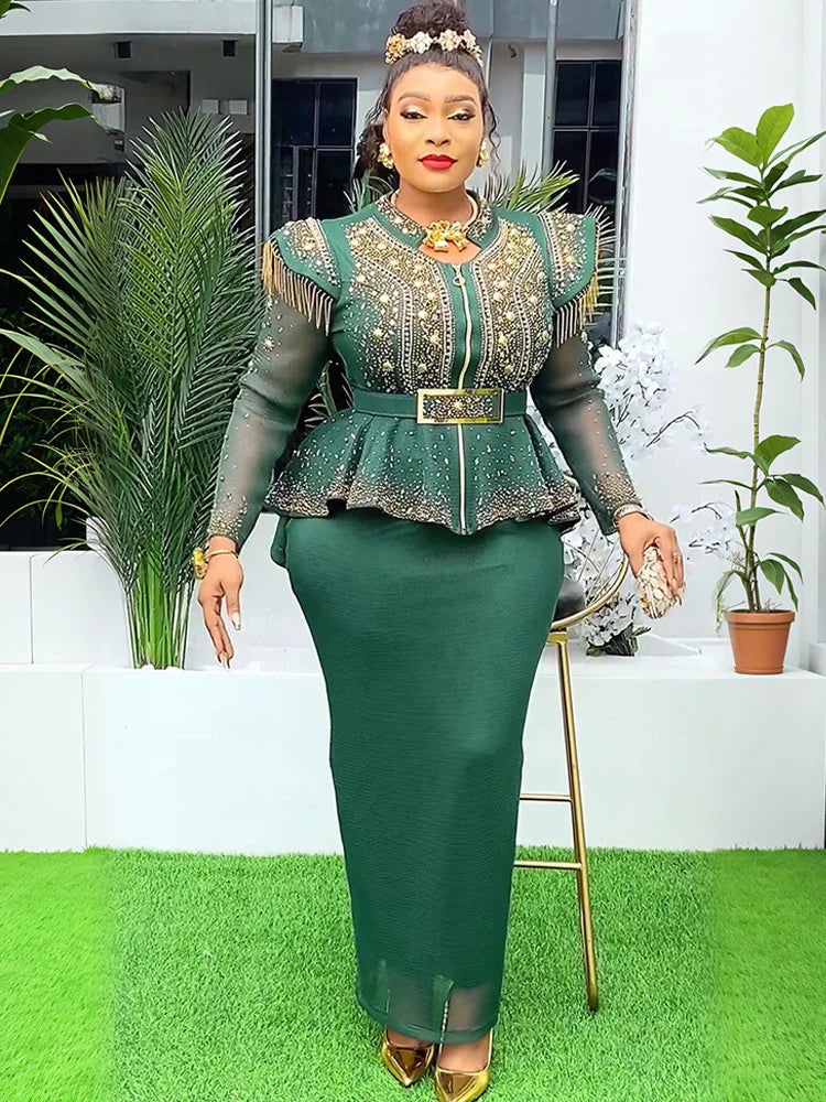 A woman wears a dark green two-piece set featuring a beaded peplum top and a matching long skirt.