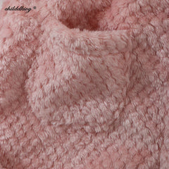 A close-up view of a soft, pink, textured flannel fabric used for children's loungewear.