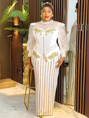 A woman wears a white floor-length gown with gold sequin stripes, puff sleeves, and floral accents.
