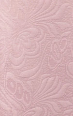 A close-up view of a light pink fabric featuring an embossed floral damask pattern.