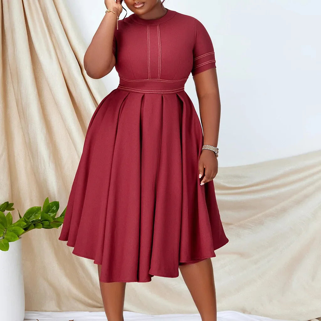 A plus size burgundy short-sleeve A-line dress with white contrast stitching and a pleated skirt.
