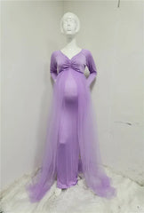 A long-sleeved lavender maternity dress with a V-neck, ruched bodice, and a sheer tulle cape.