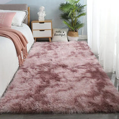 A rectangular, plush, dusty pink area rug with a soft, shaggy texture on a bedroom floor.