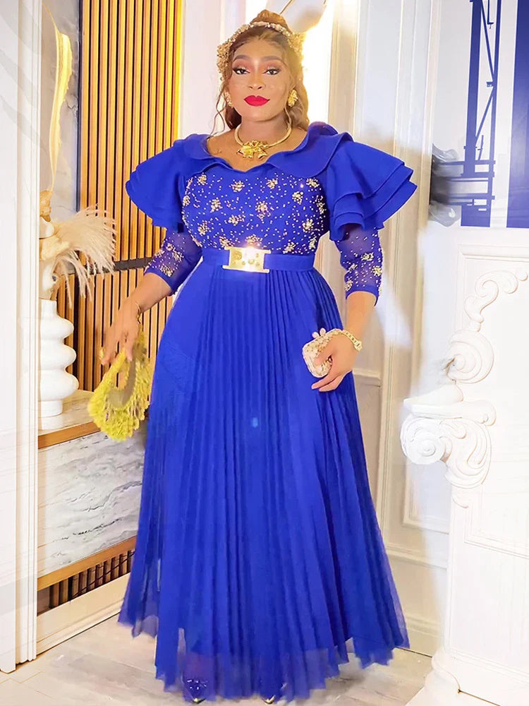 A woman wears a royal blue floor-length A-line gown with butterfly sleeves and crystal embellishments.