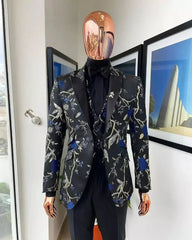 A three-piece black suit featuring a floral jacquard blazer, matching vest, and solid trousers.