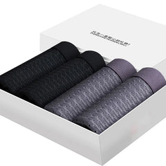 A set of four breathable mesh boxer briefs in black and grey arranged in a white gift box.