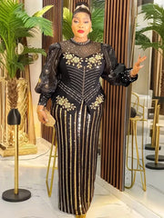 A woman wears a black floor-length gown with gold sequin stripes, puff sleeves, and floral accents.
