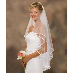 A two-layer white shoulder-length wedding veil featuring a simple ribbon edge and a hair comb.