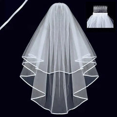 A two-layer white shoulder-length wedding veil with a ribbon edge and an attached hair comb.
