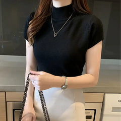 A woman wears a black short-sleeved turtleneck knitted top with a slim fit.