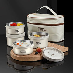 A set of three stackable stainless steel lunch containers with a matching insulated carry bag.
