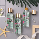 Three bottles of Sunshine Love fragrance spray arranged on a gray surface with decorative items.