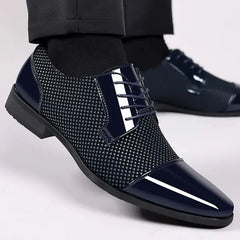 A close-up of a person in dark trousers and black socks wearing Trending Classic Men Dress Shoes—black patent leather Oxfords with a glossy finish, pointed toe, patterned texture, and formal lace-up design.
