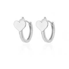 A pair of silver hoop earrings featuring a small heart charm attached to the top.