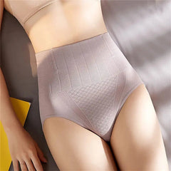 A woman wearing Underwear Bragas Fajas Women Shaper Thong Bodyshaper in nude high waist shapewear lies on a bed, showing her midsection and upper thighs with a yellow object nearby.
