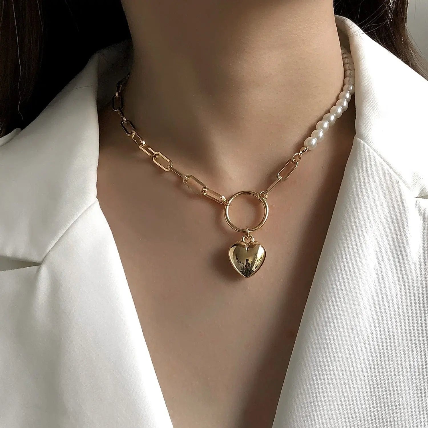 A woman in a white blazer models the Vintage Style Simple 6MM Pearl Chain Choker Necklace, featuring half gold chain links, half pearls, and a central shell pendant for a chic, modern look.
