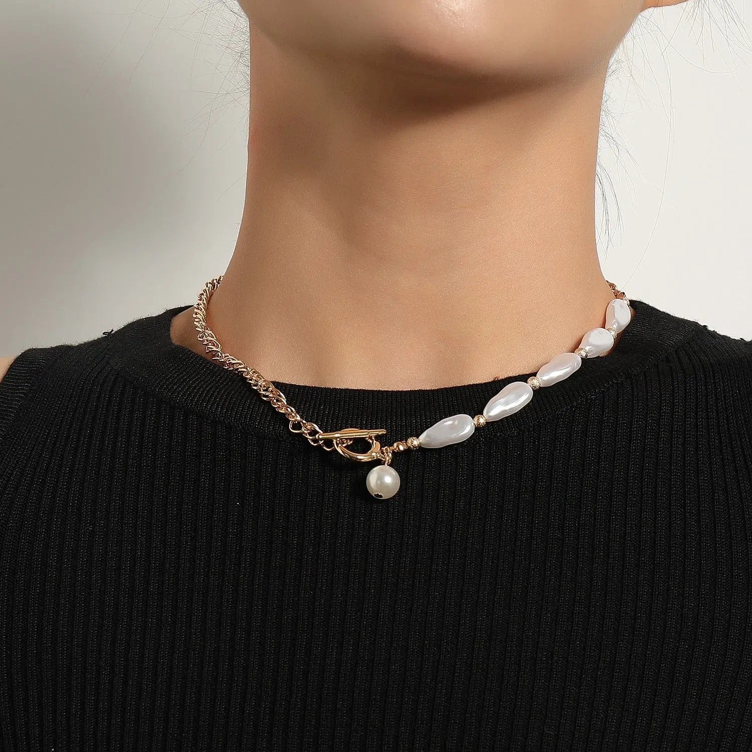 A person wears a black ribbed top and the "Vintage Style Simple 6MM Pearl Chain Choker Necklace For Women" featuring gold chain, white pearls, and a shell pendant, set against a plain light background.