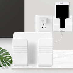 A white wall-mounted mobile phone holder shown with a phone charging inside it.