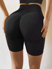 A person wears black high-waisted seamless workout biker shorts with a booty-lifting design.