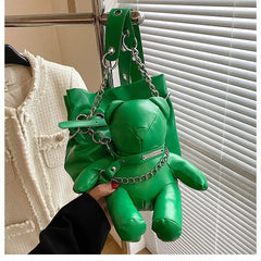 A bright green bucket bag featuring a plush teddy bear design with a silver chain strap.
