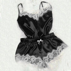 A black satin pajama set featuring a sleeveless camisole and shorts with white lace trim.
