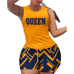 A woman wears a yellow sleeveless top with the word Queen and matching geometric print shorts.