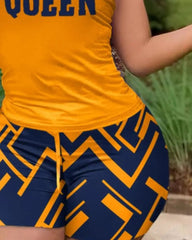 A sleeveless yellow top with the word Queen and matching blue shorts with a geometric print.