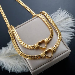 A gold-plated stainless steel jewelry set featuring a chain necklace and bracelet with heart charms.