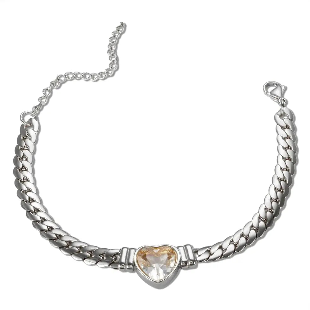 A silver-toned chain bracelet featuring a central heart-shaped crystal pendant.