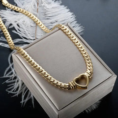 A gold-plated stainless steel chain necklace featuring a central heart-shaped pendant.