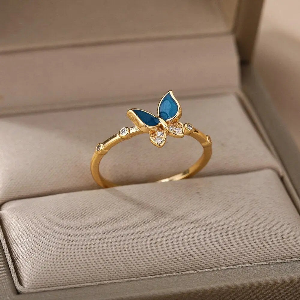 A gold color stainless steel Zircon Engagement Wedding Ring for women with a blue and white butterfly design and small cubic zirconia, displayed in a beige jewelry box. Perfect finger jewelry or birthday gift. Free shipping.