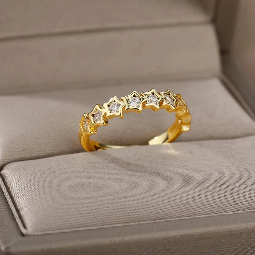 The Zircon Engagement Wedding Ring for women features gold-colored stainless steel with star-shaped cubic zirconia settings, beautifully presented in a beige jewelry box. Perfect as a 2023 finger jewelry birthday gift with free shipping.