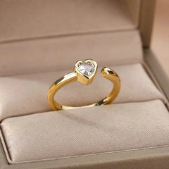 The Zircon Engagement Wedding Ring for women features a gold-colored stainless steel open band with a heart-shaped cubic zirconia, presented in a beige jewelry box—ideal as finger jewelry or a birthday gift, with free shipping.