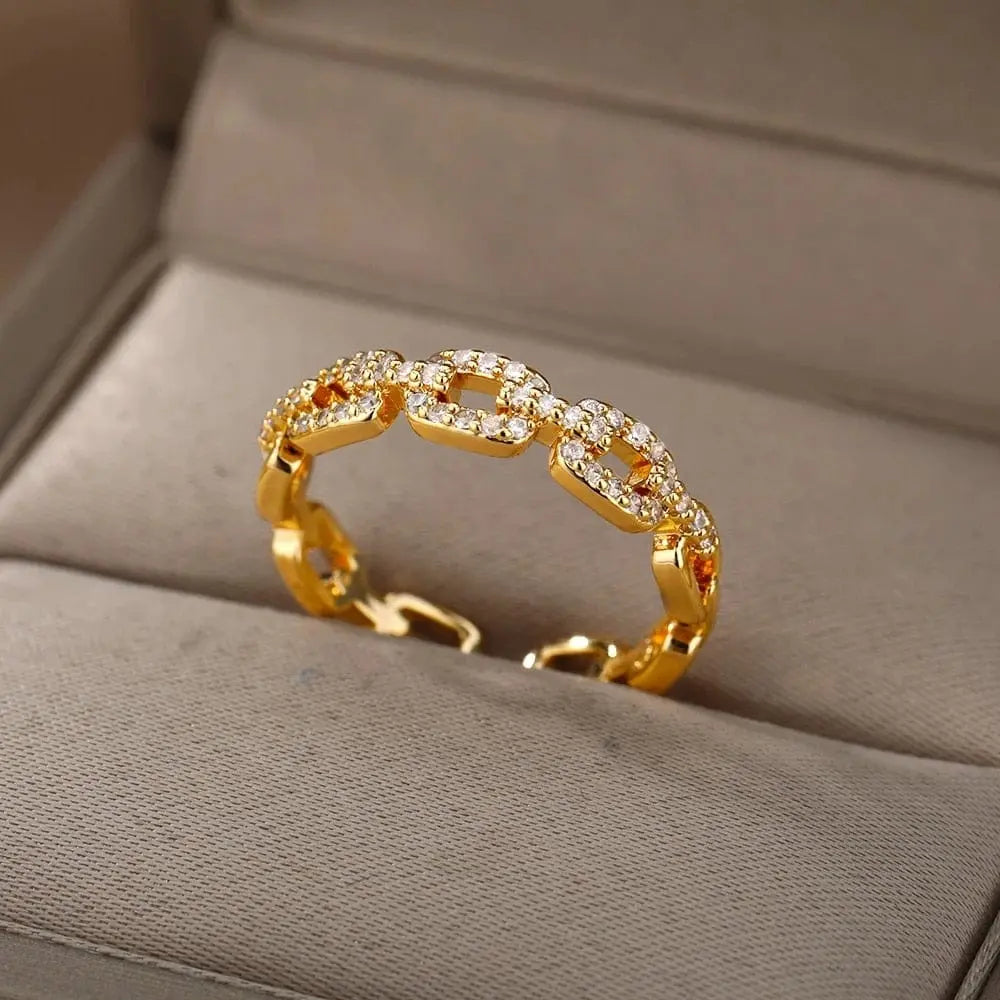 The Zircon Engagement Wedding Ring for women features a gold color chain-link design with sparkling cubic zirconia, crafted from stainless steel. Presented on a beige jewelry box, it's a perfect 2023 gift with free shipping.