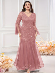 A dusty rose sequin lace mermaid gown featuring a V-neck and long bell sleeves.