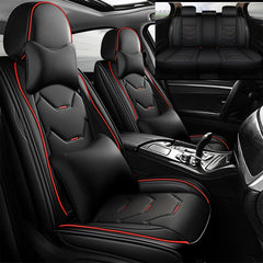 Black faux leather car seat covers with red piping and matching headrest pillows.